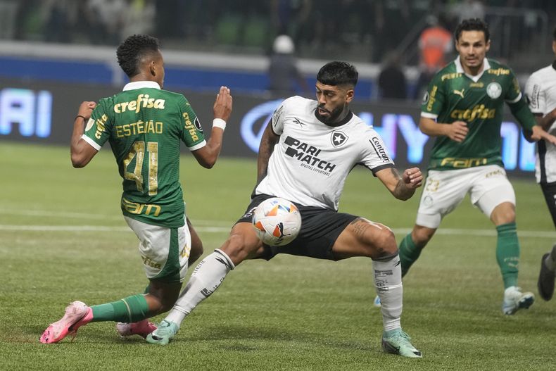 El brasileño Alexander Barboza del Botofago pelea por el balón con Estevao del Palmeiras en el encuentro de los octavos de final de la Copa Libertadores en Sao Paulo el miércoles 21 de agosto del 2024. (AP Foto/Andre Penner)