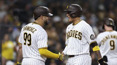 Gary Sánchez, de los Padres de San Diego, felicita a su compatriota dominicano Manny Machado, quien anotó en un doble ante los Guardianes de Cleveland, el martes 13 de junio de 2023 (AP Foto/Derrick Tuskan)