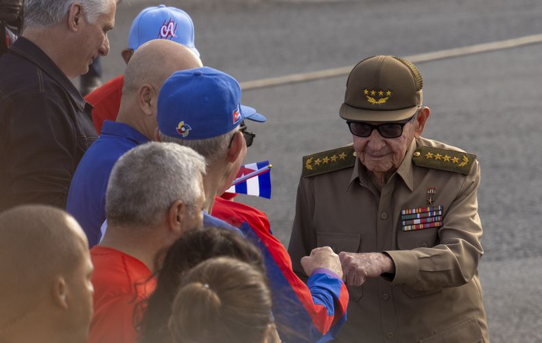 El expresidente Raúl Castro, a la derecha, choca el puño con un hombre a su llegada a una manifestación contra el embargo estadounidense y en demanda de la eliminación de Cuba de la lista de países que patrocinan el terrorismo, en La Habana, Cuba, el viernes 20 de diciembre de 2024. (Foto AP/Ramon Espinosa)