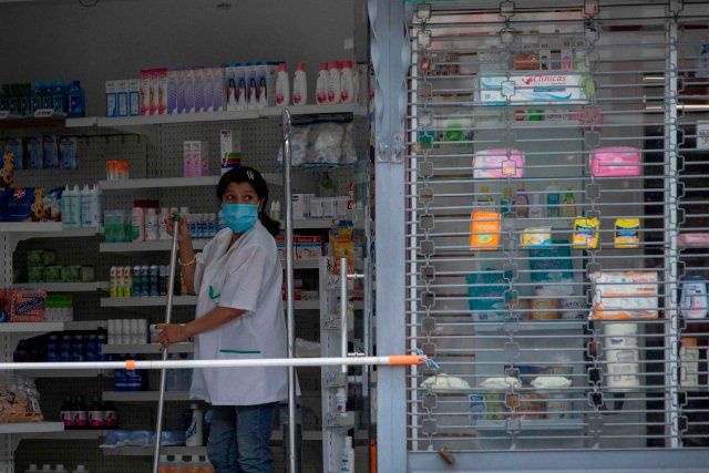 La trabajadora de una farmacia observa el mostrador, el 14 de abril de 2021, en Caracas (Venezuela). EFE/RAYNER PEÑA R.