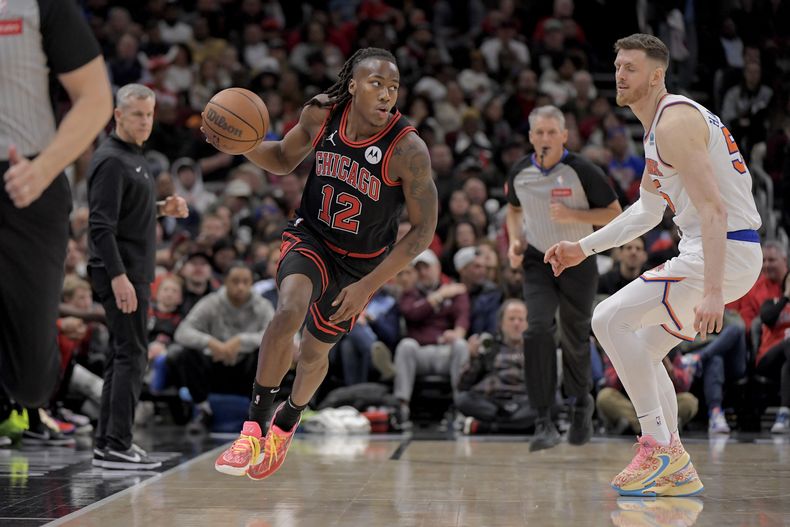 Ayo Dosunmu, de los Bulls de Chicago, avanza frente a Isaiah Hartenstein, de los Knicks de Nueva York, en el partido del viernes 5 de abril de 2024 (AP Foto/Mark Black)