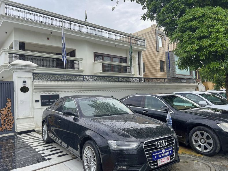 Autos de lujo con matrículas diplomáticas falsas, estacionados en el exterior de un edificio residencial alquilado en el que se gestionaba una embajada falsa, en Ghaziabad, a las afueras de Nueva Delhi, India, el 21 de julio de 2025. (Equipo Especial de la Policía de Uttar Pradesh vía AP)