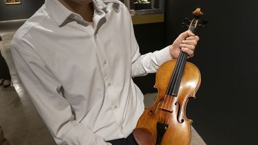 El violinista Stefan Jackiw sostiene el Joachim-Ma Stradivarius de 1714 en la casa de subastas Sothebys en Nueva York el lunes 3 de febrero de 2025. (Foto AP/Ted Shaffrey)