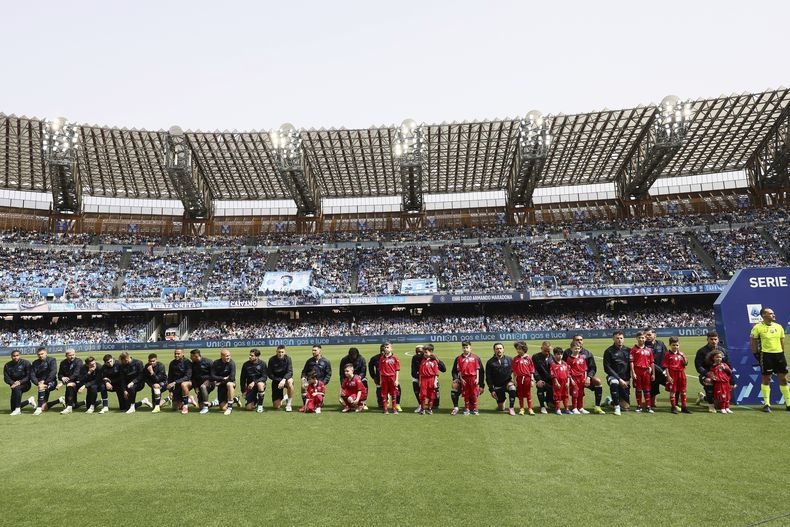 Jugadores del Napoli se hincan antes del encuentro ante Atalanta en el Estadio Diego Armando Maradona el sábado 30 de marzo del 2024. (Alessandro Garofalo/LaPresse via AP)