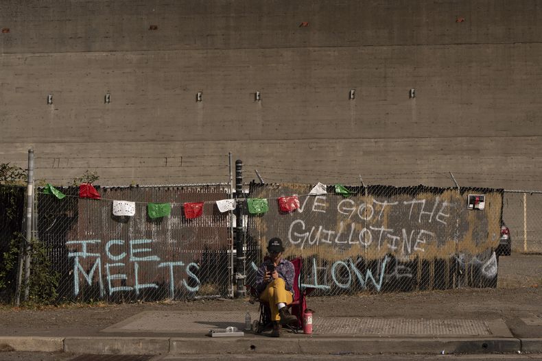 Un voluntario documenta los vehículos que entran en el edificio del Servicio de Inmigración y Control de Aduanas de Estados Unidos en Portland, Oregon, el martes 9 de septiembre de 2025. (AP Foto/Jenny Kane)