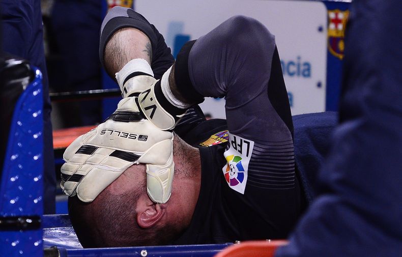 El arquero del Barcelona, V&iacute;ctor Vald&eacute;s, se tapa el rostro tras sufrir una lesi&oacute;n en un partido contra Celta de Vigo el mi&eacute;rcoles, 26 de marzo de 2014, en Barcelona. (AP Photo/Manu Fernandez)
