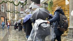 Personas hacen fila fuera de la chocolatería Lindt para comprar una edición limitada de Chocolate Dubái, el jueves 14 de noviembre de 2024, en Aachen, Alemania. (AP Foto/Daniel Niemann)