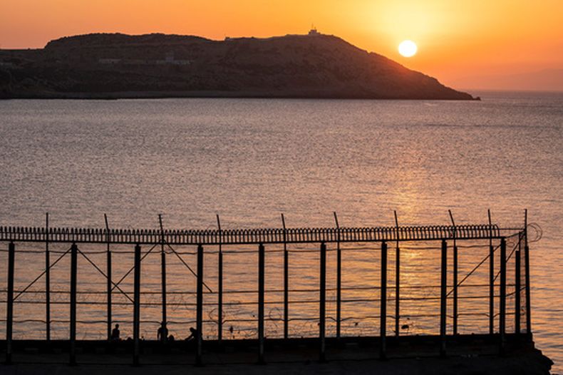 ARCHIVO – Varios hombres pescan en el lado marroquí de la frontera con España, vistos desde la localidad de Benzu, en el enclave español de Ceuta, el 3 de junio de 2021. (AP Foto/Bernat Armangue, Archivo)