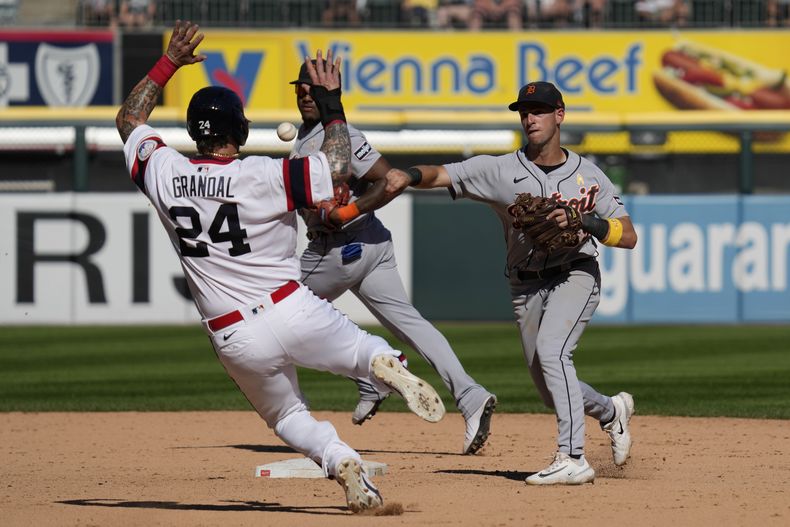 Zack Short, derecha, de los Tigres de Detroit, lanza a primera para sacar Oscar Colas, de los Medias Blancas de Chicago, después de forzar en segunda a Yasmani Grandal en segunda, durante la novena entrada del juego de béisbol del domingo 3 de septiembre de 2023. (AP Foto/Nam Y. Huh)