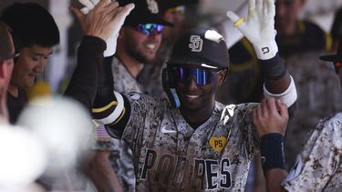 Jurickson Profar, centro, de los Padres de San Diego, es felicitado en el dugout después de conectar un jonrón solitario contra los Medias Blancas de Chicago en la tercera entrada el domingo 22 de septiembre de 2024 en San Diego. (AP Foto/Derrick Tuskan)