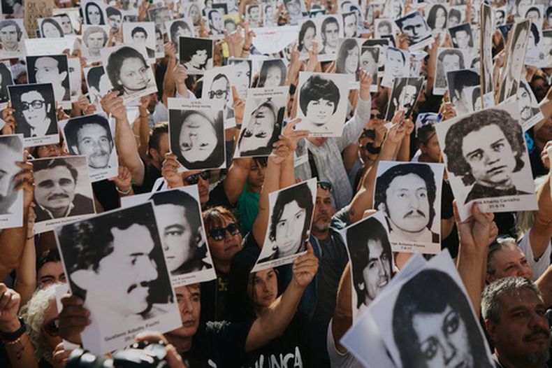 Manifestantes sostienen fotos de personas que desaparecieron durante la última dictadura militar en Argentina (1976-1983) durante una concentración por el aniversario del golpe de Estado que llevó al régimen militar al poder en Buenos Aires, Argentina, el martes 24 de marzo de 2026. (AP Foto/Víctor R. Caivano)