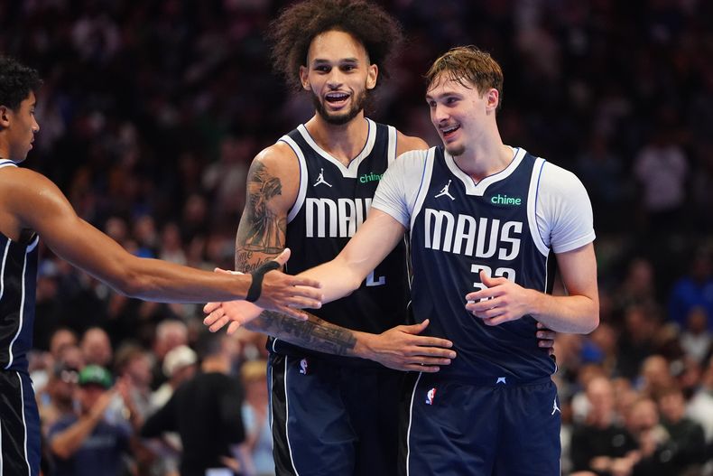 Cooper Flagg (32), de los Mavericks de Dallas, festeja con sus compañeros Max Christie (izquierda) y P.J. Washington (centro), durante el duelo ante los Pelicans de Nueva Orleáns, el viernes 21 de noviembre de 2025 (AP foto/LM Otero)