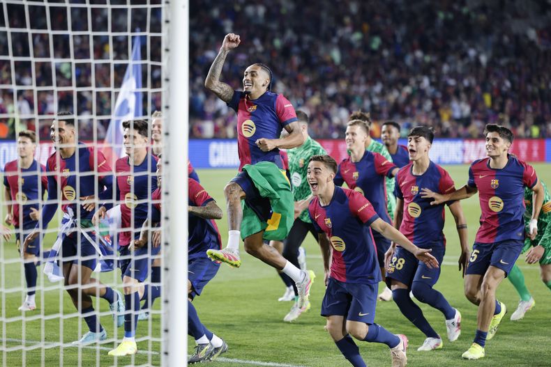 Raphinha (centro) lidera el festejo de los jugadores del Barcelona por su consagración como campeones de la Liga de España, el domingo 18 de mayo de 2025. (AP Foto/Joan Monfort)