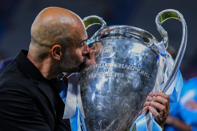 El técnico del Manchester City Pep Guardiola le da un beso al trofeo de campeón de la Liga de Campeones al vencer al Inter de Milán en la final en Estambul, el 10 de junio de 2023. El viernes 23 de junio del 2023, anuncian que Estados Unidos recibirá la edición 2025 del Mundial de Clubes. (AP Foto/Manu Fernández)