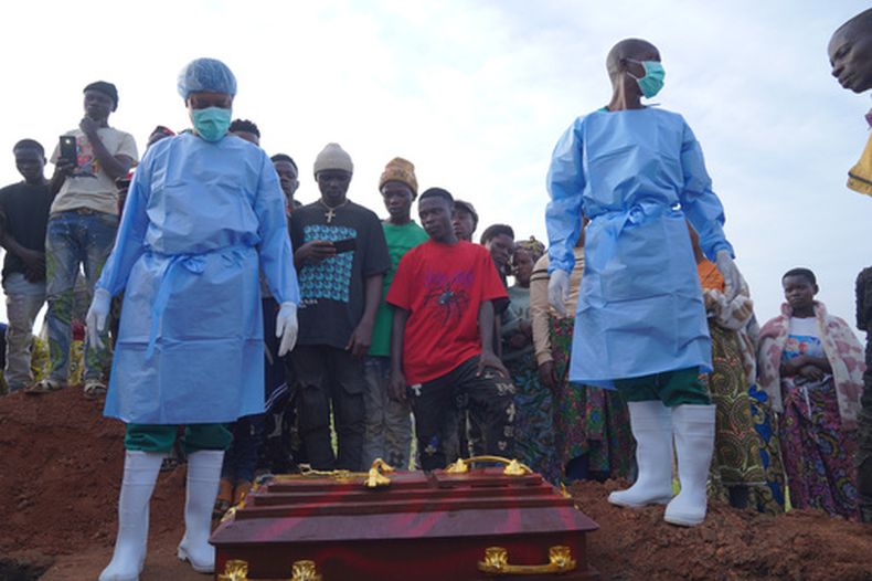 Gente vestida con trajes de protección se prepara para bajar a una tumba el ataúd con los restos de Mave Mercienne, de tres años, que murió de ébola, en Bunia, en la provincia de Ituri, en el este de República Democrática del Congo, el martes 18 de agosto de 2026. (AP Foto/Dieudonne Dirole)