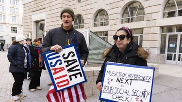 Priya Kathpal, trabajadora contratada por la Agencia de Estados Unidos para el Desarrollo Internacional (USAID, por sus siglas en inglés), a la derecha, y Taylor Williamson, a la izquierda, que trabaja para una empresa contratada por USAID, protestan ante la sede de USAID el lunes 10 de febrero de 2025, en Washington. (AP foto/Manuel Balce Ceneta)