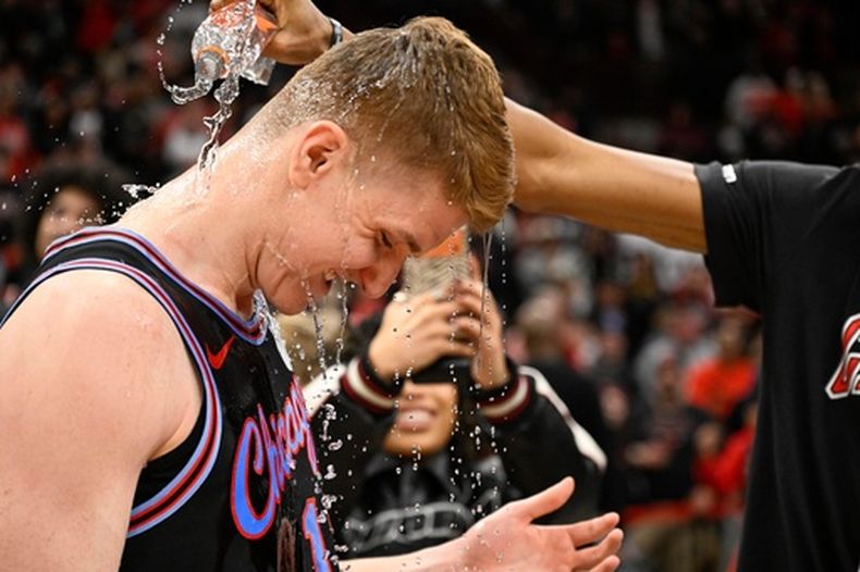 Kevin Huerter (13), de los Bulls de Chicago, es bañado con agua tras un juego de baloncesto de la NBA contra los Celtics de Boston, el sábado 24 de enero de 2026, en Chicago. Huerter anotó el triple ganador del encuentro. (AP Photo/Matt Marton)