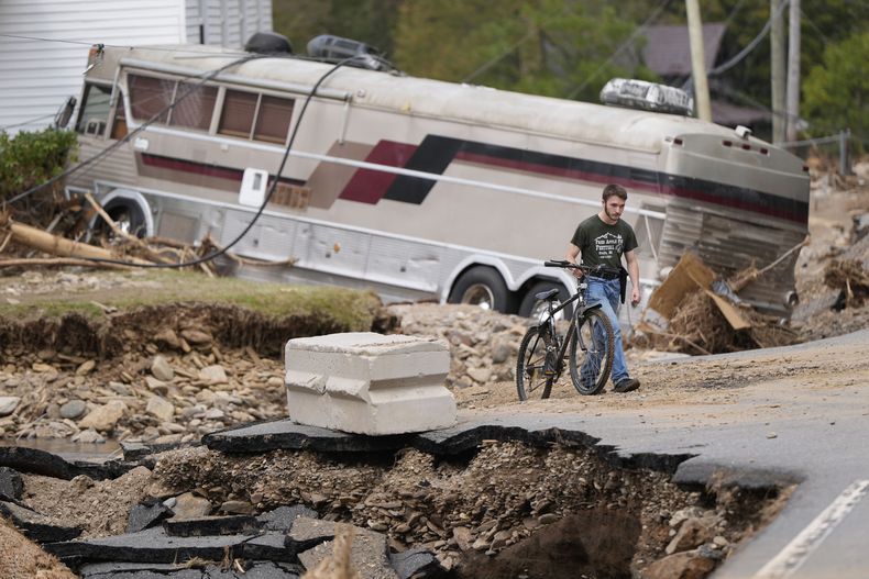 Dominick Gucciardo camina hacia su casa tras el paso del huracán Helene, el jueves 3 de octubre de 2024, en Pensacola, Carolina del Norte. (AP Foto/Mike Stewart)