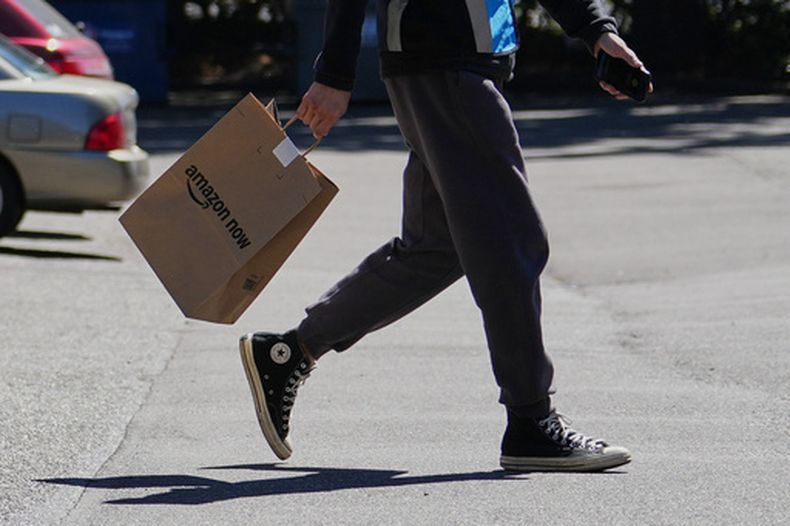 Un conductor recoge una orden en un local de Amazon Now, el lunes 11 de mayo de 2026, en Bellevue, Washington. (AP Foto/Lindsey Wasson)
