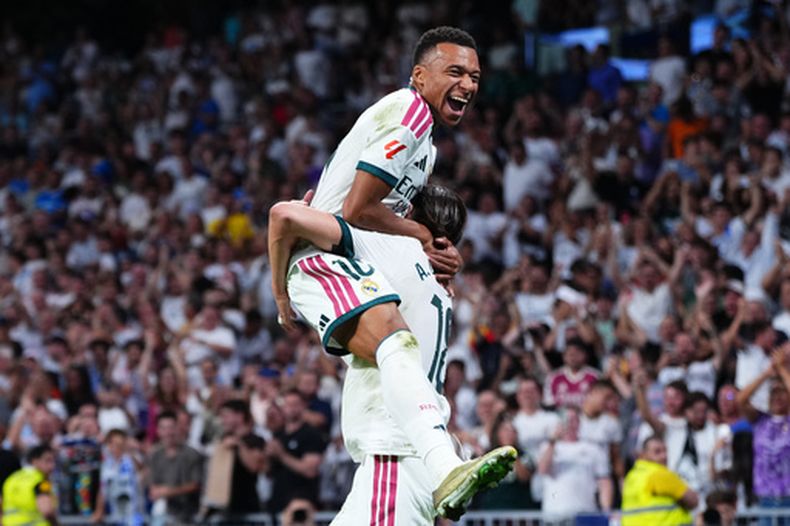 Kylian Mbappé, del Real Madrid, salta a los brazos de Álvaro Carreras, quien anotó el segundo tanto de su club ante el Rayo Vallecano, el sábado 12 de septiembre de 2026 (AP Foto/Manu Fernández)