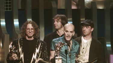 ARCHIVO - Michael Stipe, de la banda R.E.M., en el centro, habla mientras acepta el premio Video Vanguard durante los MTV Video Music Awards de 1995 en el Radio City Music Hall de Nueva York el 7 de septiembre de 1995. A sus lados se encuentran sus compañeros de banda, de izquierda a derecha: Mike Mills, Peter Buck y Bill Berry. (Foto AP/Bebeto Matthews, archivo)