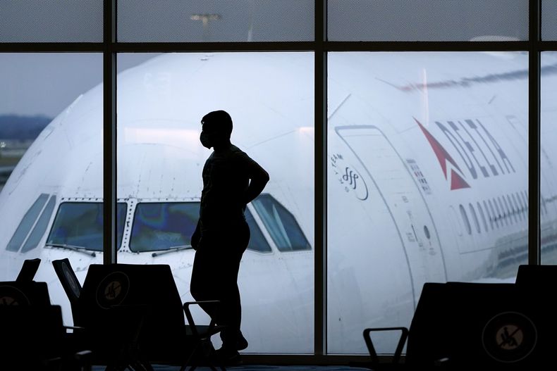 ARCHIVO - Un pasajero espera un vuelo de Delta Airlines en el Aeropuerto Internacional Hartsfield-Jackson en Atlanta el 18 de febrero de 2021. (AP Foto/Charlie Riedel, Archivo)