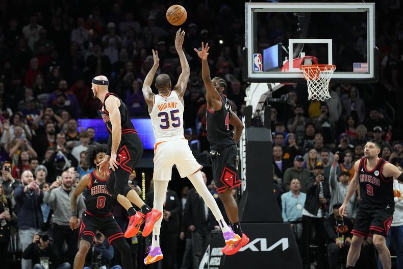 Kevin Durant (35), de los Suns de Phoenix, dispara el tiro ganador mientras Patrick Williams, derecha, intenta defender su canasta, en la segunda mitad del juego de baloncesto de la NBA, el lunes 22 de enero de 2024, en Phoenix. (AP Foto/Matt York)