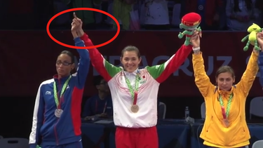 americateve | Inconforme, la cubana y Campeona del Mundo en la División de -73 kg, Glenhis Hernández, levantó el dedo medio en señal de protesta en el podio de la premiación de la categoría en el taekwondo de los JCC Veracruz 2014.