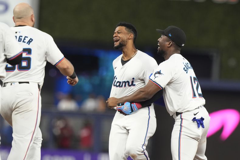 Peloteros de los Marlins de Miami corren al campo para felicitar al dominicano Otto López tras empujar la carrera de la ventaja en la novena entrada ante los Cardenales de San Luis el miércoles 19 de junio del 2024. (AP Foto/Marta Lavandier)