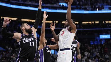 Kawhi Leonard, derecha, de los Clippers de Los Ángeles, tira y encesta el tiro ganador sperando la bocina frente a Jonas Valanciunas, izquierda, y Keegan Murray, de los Kings de Sacramento, segundo a la izquierda, en el tiempo extra durante el partido de baloncesto de la NBA, el domingo 9 de marzo de 2025, en Inglewood, California. (AP Foto/Mark J. Terrill)