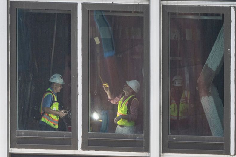 Personas inspeccionan una viga de soporte doblada dentro de un rascacielos en el 235 East 42nd Street, el 8 de julio de 2026, en Nueva York. (Foto AP/Yuki Iwamura)