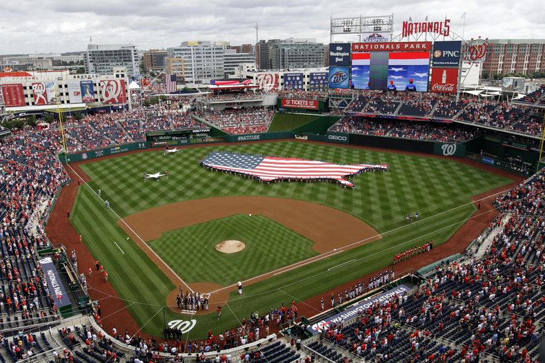 ARCHIVO - Esta fotografía de archivo del 4 de julio de 2013 muestra una bandera estadounidense, con la forma del país, en los jardines antes de un partido de béisbol entre los Nacionales de Washington y los Cerveceros de Milwaukee en el Nationals Park de Washington. El fiscal general de Washington demandó a StubHub, acusando a la plataforma de reventa de entradas de anunciar precios engañosamente bajos y luego aumentar los precios con tarifas adicionales. (Foto AP/Mark Tenally, archivo)
