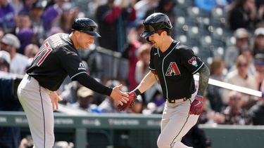 El entrenador de tercera base de los Diamondbacks de Arizona J.R. House felicita a Corbin Carroll mientras rodea las bases tras su jonrón de dos carreras en la cuarta entrada ante los Rockies de Colorado el domingo 17 de mayo del 2026. (AP Foto/David Zalubowski)