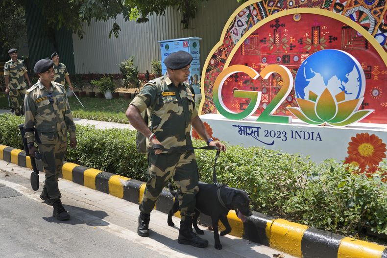 Soldados paramilitares indios patrullan con perros rastreadores por las inmediaciones del recinto que albergará la cumbre del Grupo de los 20, en Nueva Delhi, India, el 7 de septiembre de 2023. (AP Foto/Manish Swarup)