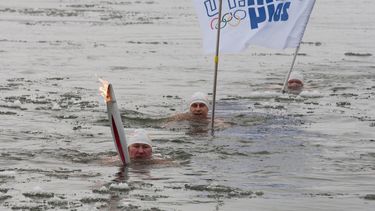 americateve | Alexander Brylin, izquierda, nada con la antorcha ol&iacute;mpica de los Juegos de Invierno de sochi el martes, 19 de noviembre de 2013, en el r&iacute;o Amur en Blagoveshchensk, Rusia. Foto suministrada por Olympictorch2014.com.  (AP Photo/Olympictorch20