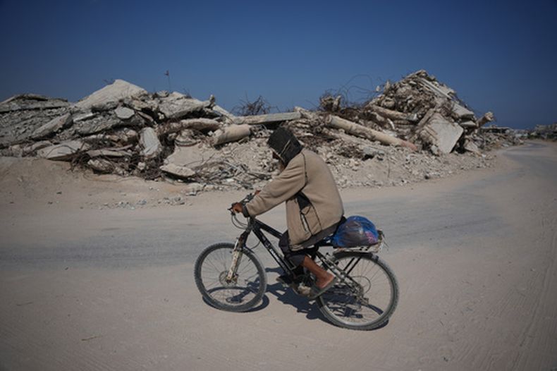 Un palestino en bicicleta cerca de un edificio destruido por un bombardeo israelí en Jan Yunis, Franja de Gaza, el m31 de julio del 2026. (AP foto/Abdel Kareem Hana)