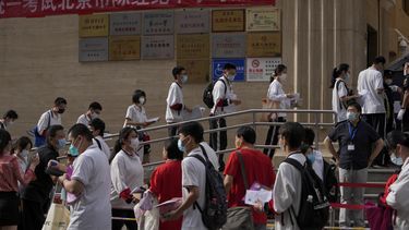 Estudiantes se forman para entrar a una escuela en el primer día de los exámenes de ingreso a la educación superior de China, conocido como el goakao, en Beijing, el martes 7 de junio de 2022. (AP Foto/Andy Wong, Archivo )
