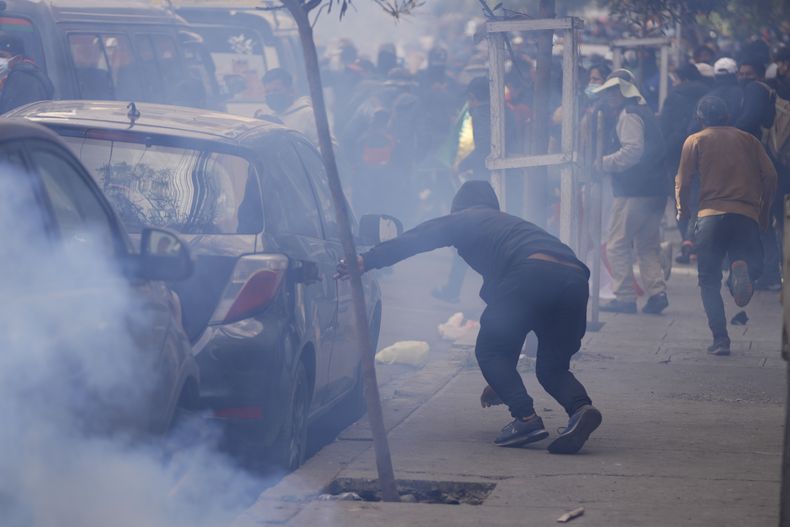 Seguidores del expresidente Evo Morales huyen del gas lacrimógeno lanzado por la policía, en una protesta en reclamo de su inhabilitación como candidato de cara a las próximas elecciones presidenciales, cerca del Tribunal Supremo Electoral en La Paz, Bolivia, el jueves 29 de mayo de 2025. (AP Foto/Juan Karita)