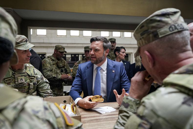 El vicepresidente de Estados Unidos, JD Vance, come una hamburguesa de Shake Shack con miembros de la Guardia Nacional en Union Station, en Washington, el 20 de agosto de 2025. (Alexander Drago/Pool vía AP)