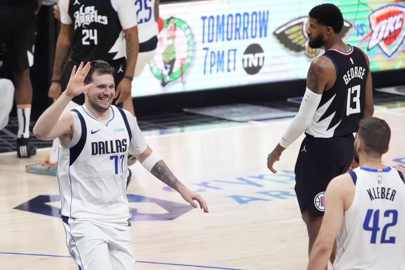 El esloveno Luka Doncic (izquierda), de los Mavericks de Dallas, festeja con Maxi Kleber, en el segundo partido de la serie de playoffs ante los Clippers de Los Ángeles, el martes 23 de abril de 2024 (AP Foto/Mark J. Terrill)