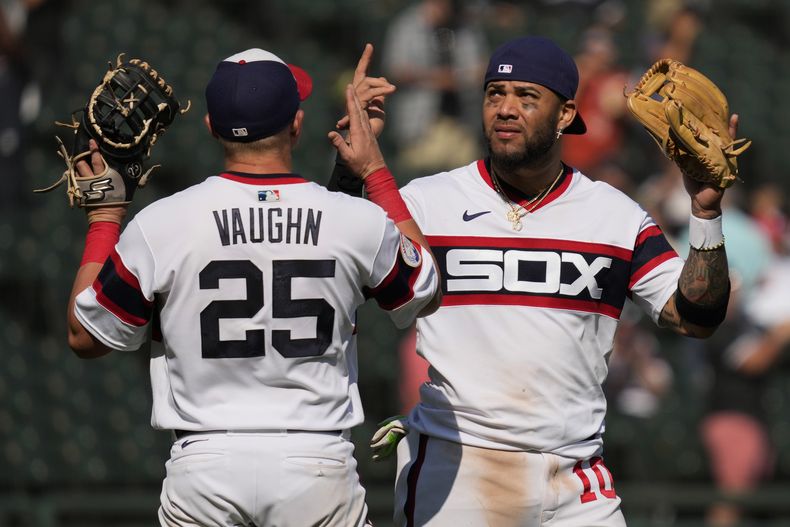 El tercera base cubano Yoán Moncada junto al primera base Andrew Vaughn celebran la victoria de los Medias Blancas sobre los Atléticos de Oakland, en Chicago. Domingo 27 de agosto de 2023. (AP Foto/Nam Y. Huh)
