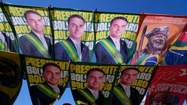 Un vendedor ambulante vende banderas de campaña de los principales candidatos presidenciales de Brasil: el senador Flavio Bolsonaro y el actual presidente Luiz Inácio Lula da Silva, en Brasilia, Brasil, el martes 29 de septiembre de 2026. (AP Foto/Eraldo Peres)