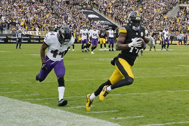 George Pickens (14), receptor de los Steelers de Pittsburgh, atrapa u pase frente al cornerback Marlon Humphrey, izquierda, de los Ravens de Baltimore, y lo lleva hasta la zona de anotación para un touchdown cerca del final del partido de la NFL, en Pittsburgh, el domingo 8 de octubre de 2023. (AP Foto/Gene J. Puskar)
