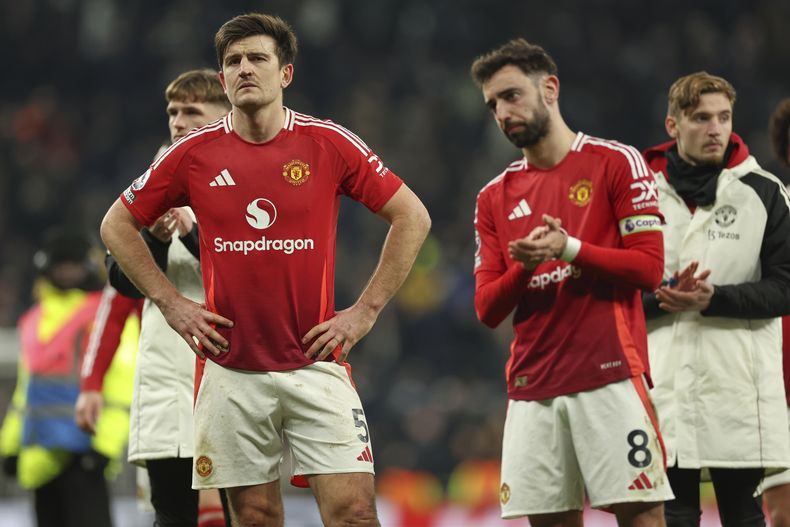 Bruno Fernandes (derecha) y Harry Maguire del Manchester United tras el partido contra Tottenham Hotspur en la Liga Premier, el domingo 16 de febrero de 2025, en Londres. (AP Foto/Ian Walton)