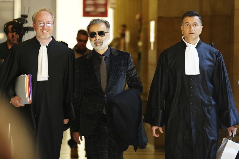 Abderrahmane Ouatiki, en el centro, quien trabajaba como recepcionista de un hotel y supuestamente fue retenido a punta de pistola por ladrones durante el robo a mano armada contra Kim Kardashian en 2016, llega al palacio de justicia el lunes 28 de abril de 2025 en París. (Foto AP/Aurelien Morissard)
