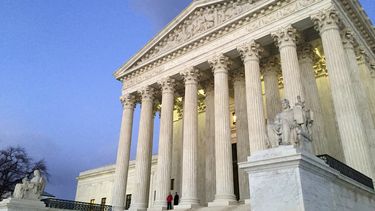 ARCHIVO - Gente de pie en las escaleras de la Corte Suprema al atardecer en Washington, el 13 de febrero de 2016. (AP Foto/Jon Elswick, Archivo)