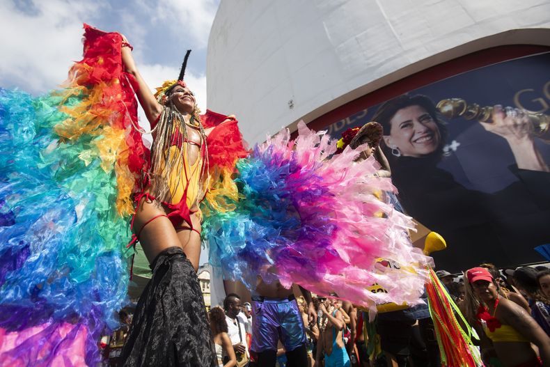 ARCHIVO - Juerguistas desfilan frente a un cartel de la actriz Fernanda Torres, nominada al premio Oscar, durante la fiesta callejera Caxias Water Planet previa al carnaval, en Duque de Caxias, Brasil, el 9 de febrero de 2025. (AP Foto/Bruna Prado, archivo)