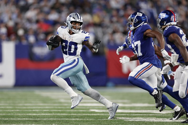 Tony Pollard de los Cowboys de Dallas corre con el balón mientras lo persigue la defensa de los Giants de Nueva York en el encuentro del domingo 10 de septiembre del 2023. (AP Foto/Adam Hunger)