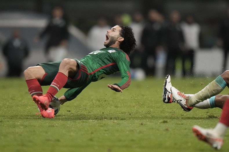 El mexicano César Huerta sufre una falta del hondureño Denil Maldonado durante un partido por los cuartos de final de la Liga de Naciones de la CONCACAF, el martes 21 de noviembre de 2023, en el estadio de Azteca de la Ciudad de México. (AP Foto/Eduardo Verdugo)