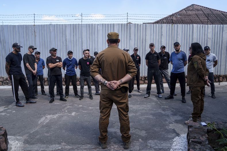 Un grupo de reos escucha a un sargento del Batallón Arey de las fuerzas ucranianas durante una entrevista en prisión, en la región de Dnipropetrovsk, Ucrania, el viernes 21 de junio de 2024. (AP Foto/Evgeniy Maloletka)